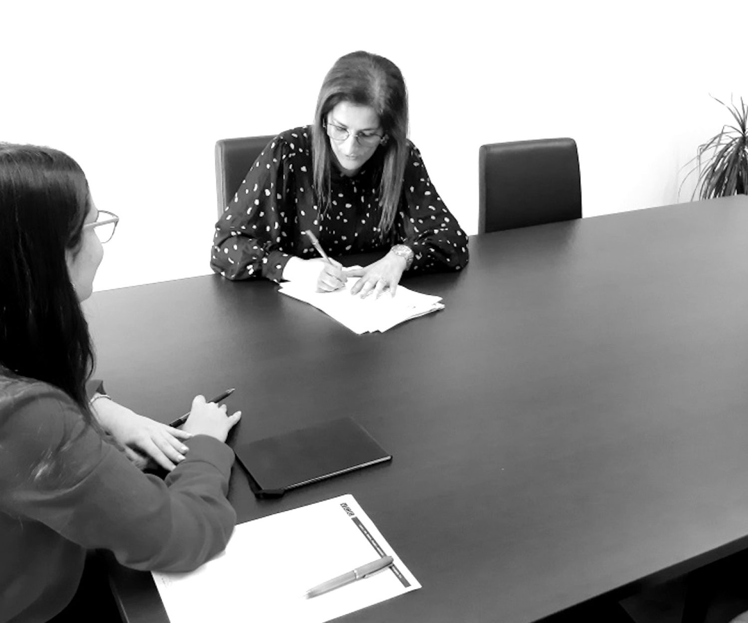 Tradutora a assinar a certificação de tradução, acompanhada por uma advogada responsável pela certificação legal.